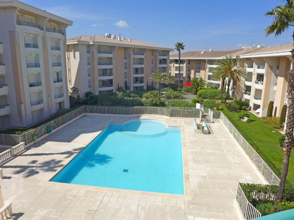 une grande piscine en face de deux immeubles d'appartements dans l'établissement Location Port Fréjus, bord de mer, à Fréjus