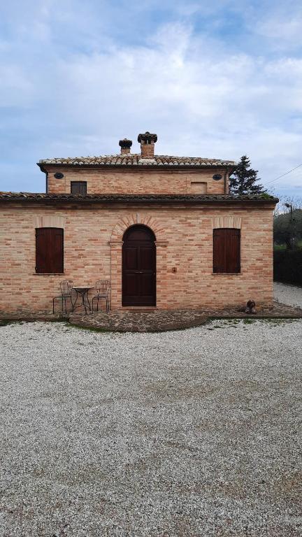 a brick building with a table in front of it at Appartamento country relax in Montelupone
