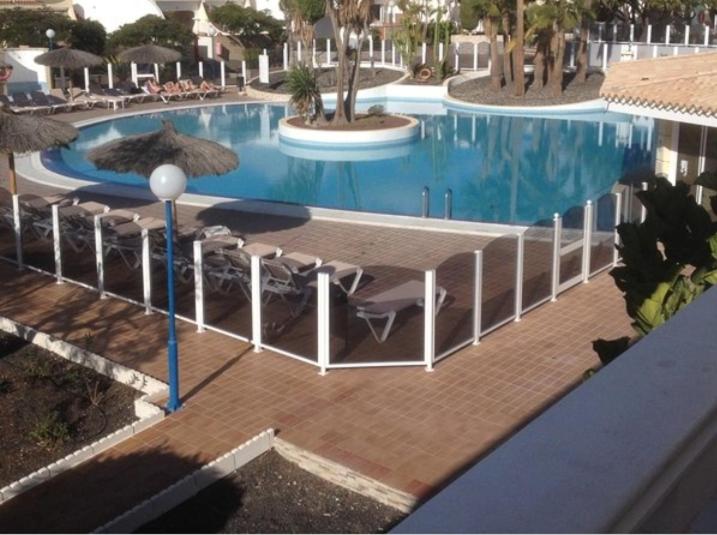 una gran piscina con sillas y sombrillas en un complejo en The Palms 2 Bed Duplex with Pool View, en San Miguel de Abona