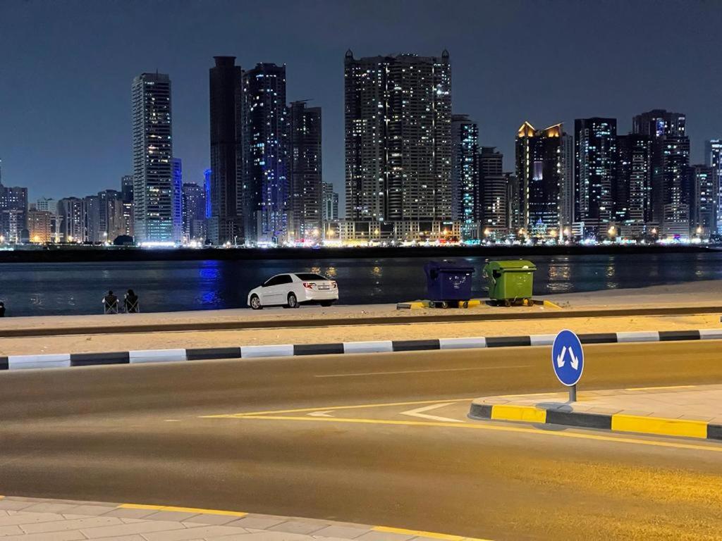 a white car parked in front of a city at night at Two Bedroom Beach residence in Sharjah