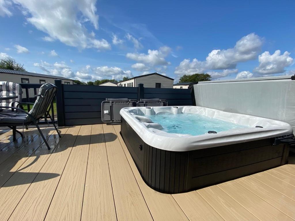 a hot tub sitting on top of a deck at Puddleducks, Dog Friendly Hot Tub Lodge in South Cerney