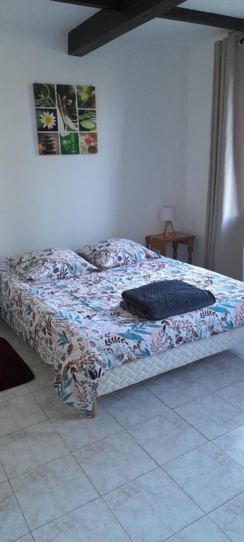 a bed sitting in a bedroom with a bedspread at Chambre indépendante à la campagne in Puycalvel Lautrec
