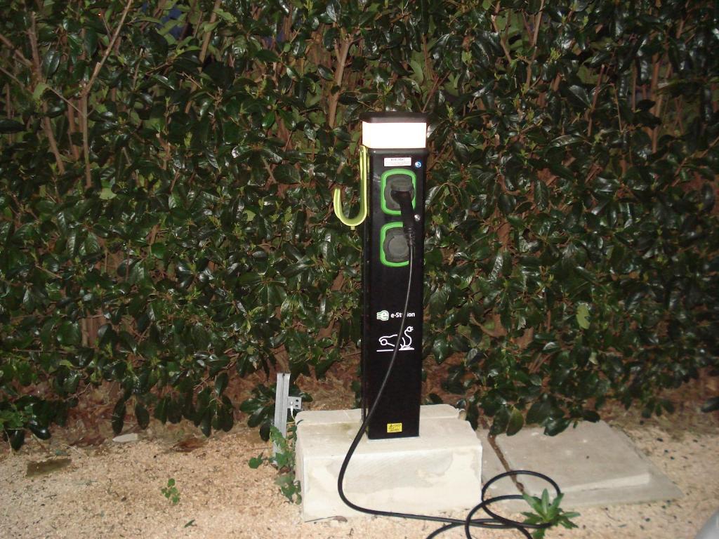 a green electric phone is plugged into a wall at Villa Lara in Polignano a Mare