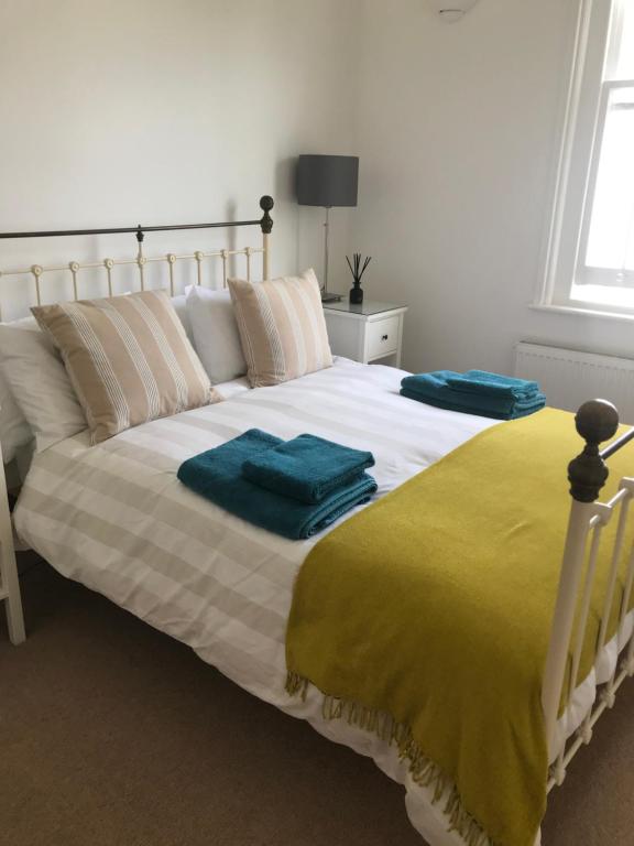 a bedroom with a large bed with two towels on it at Tree Tops Apartment in Tunbridge Wells in Royal Tunbridge Wells