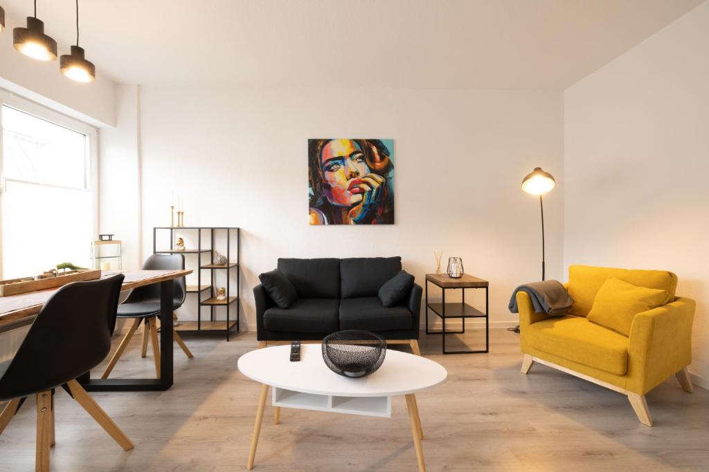 - un salon avec un canapé, des chaises et une table dans l'établissement ☆ Modern stylish flat in central location, à Wilhelmshaven