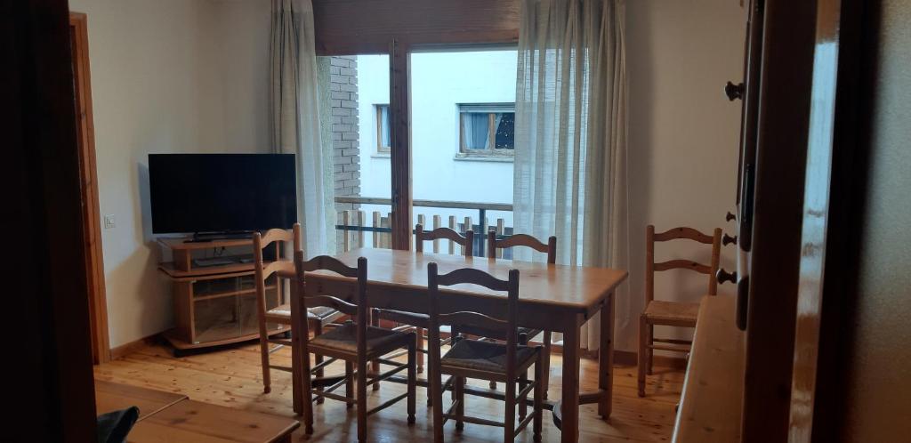 a dining room with a table and chairs and a television at APARTMENT NATURA in Puigcerdà