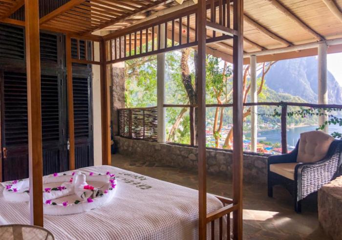 a bedroom with a bed and a view of a mountain at Green Fig Resort & Spa in Soufrière