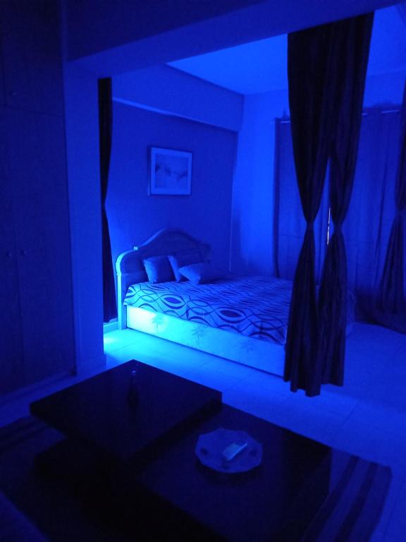 a dark room with a bed with a blue light at Old Town studio apartment in Larnaka