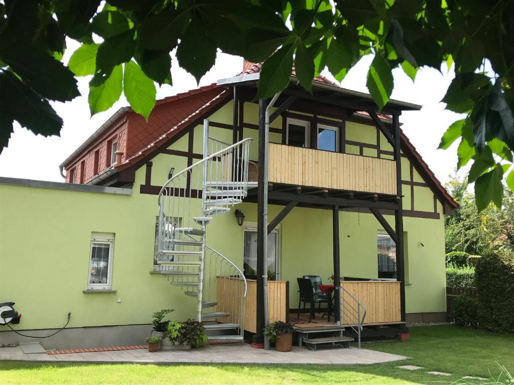 ein grünes Haus mit einer Wendeltreppe davor in der Unterkunft Quartier Nr.1 in Bad Frankenhausen