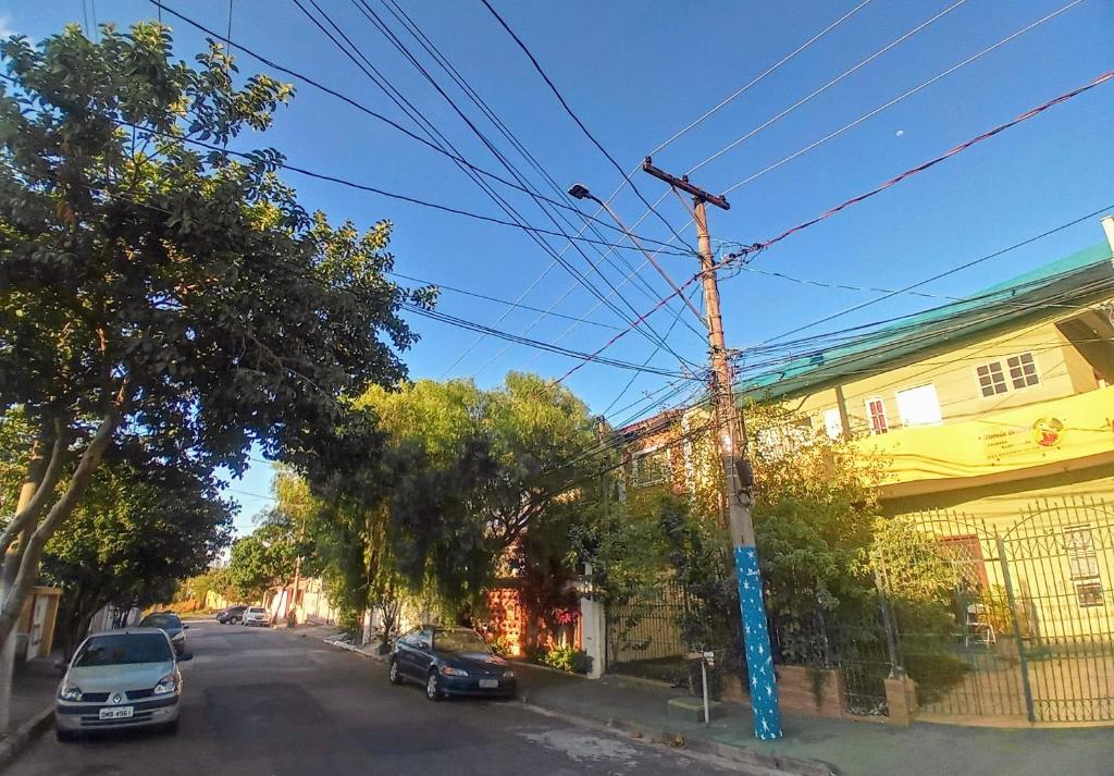 ulica z samochodami zaparkowanymi obok żółtego budynku w obiekcie Morada BemTeVi Guest House w mieście São José dos Campos