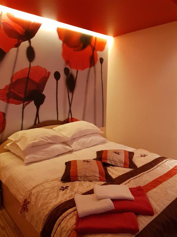 1 dormitorio con 1 cama con almohadas rojas y blancas en Trumpalaikė buto nuoma,apgyvendinimas - bekontaktis įėjimas en Rokiškis