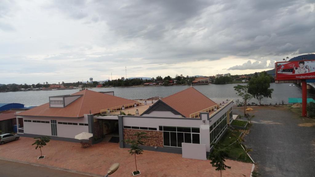 a large house with a river in the background at Kampongbay Makeng Guesthouse in Kampot