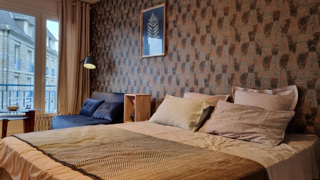 - une chambre avec un lit et un mur en briques dans l'établissement Studio Roy Gradlon Quimper, à Quimper