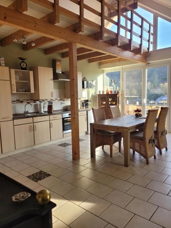 eine große Küche mit einem Holztisch und Stühlen in der Unterkunft Ahrtal Vier Sterne Ferienwohnungen Alexandra Weiler Panorama in Bad Neuenahr-Ahrweiler