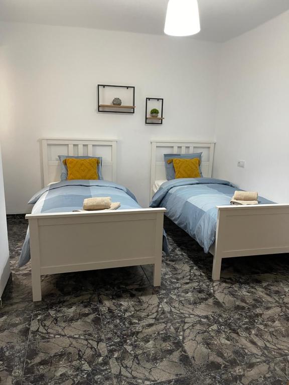 two beds in a white room with two bedsitures at UIM Mediterraneo Juana Wifi in Puerto de Sagunto