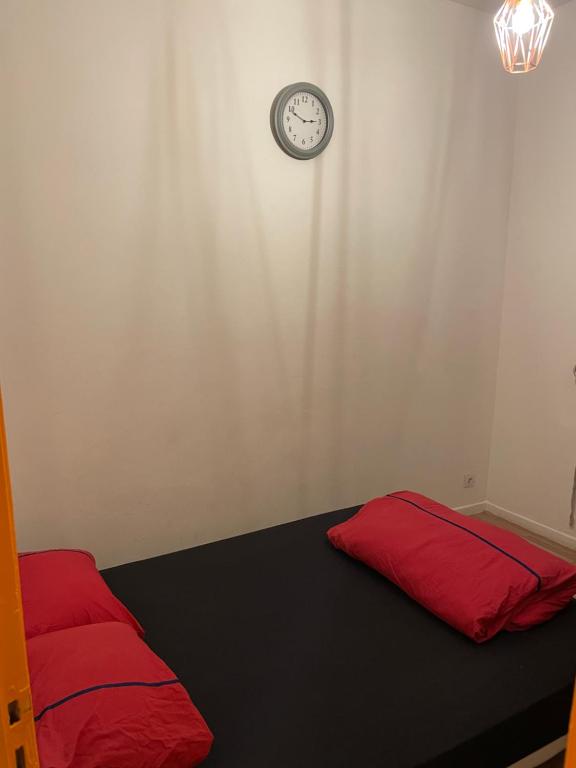 Habitación con cama con reloj en la pared en Lille Appartement Comfort en Lille
