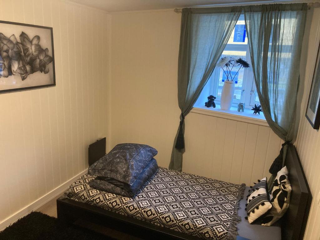 a bedroom with a bed and a window at Downtown Historical House with Renovated apartments in Ålesund