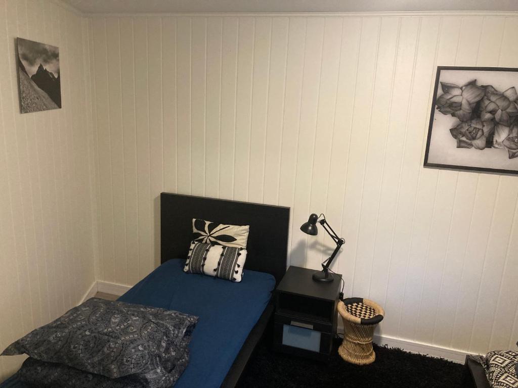 a bedroom with a bed and a lamp in it at Downtown Historical House with Renovated apartments in Ålesund