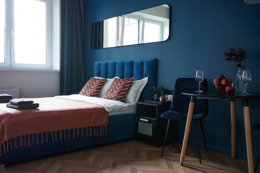 a blue bedroom with a bed and a mirror at Апартаменты Pavlov 2 в центре у Площади с удаленным заселением in Kaliningrad