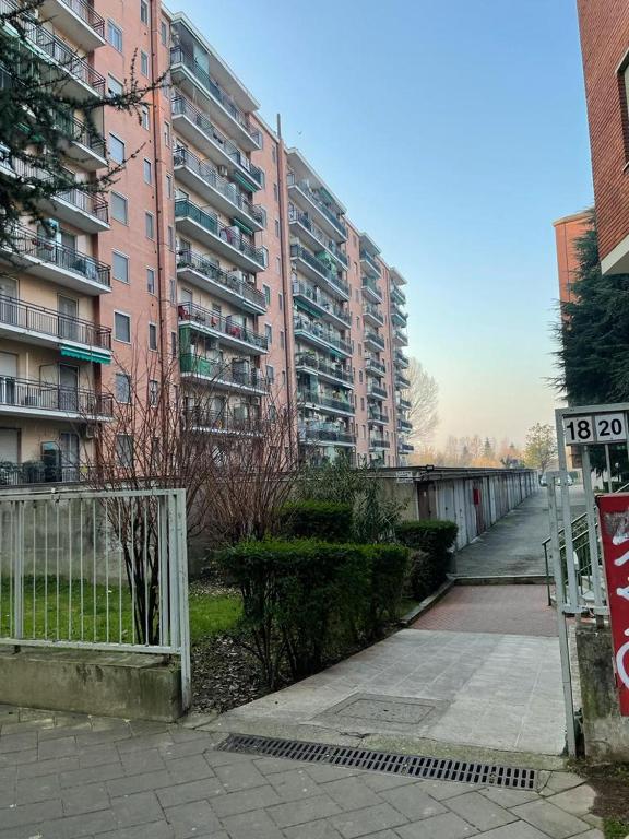 duży budynek apartamentowy z znakiem przed nim w obiekcie Kibilù - San Donato vicinanze IRCCS Policlinico w mieście San Donato Milanese