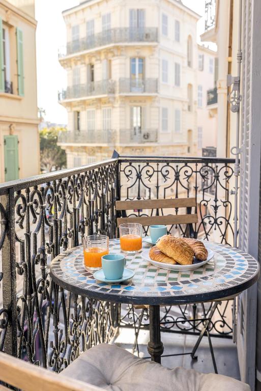 une table avec une assiette de nourriture sur un balcon dans l'établissement Appartement 2P centre de Cannes avec balcon, à Cannes