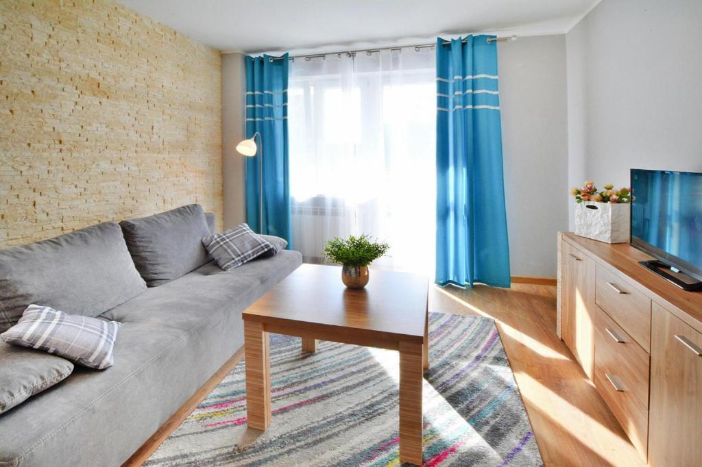 a living room with a couch and a television at Holiday flat, Kolobrzeg in Kołobrzeg