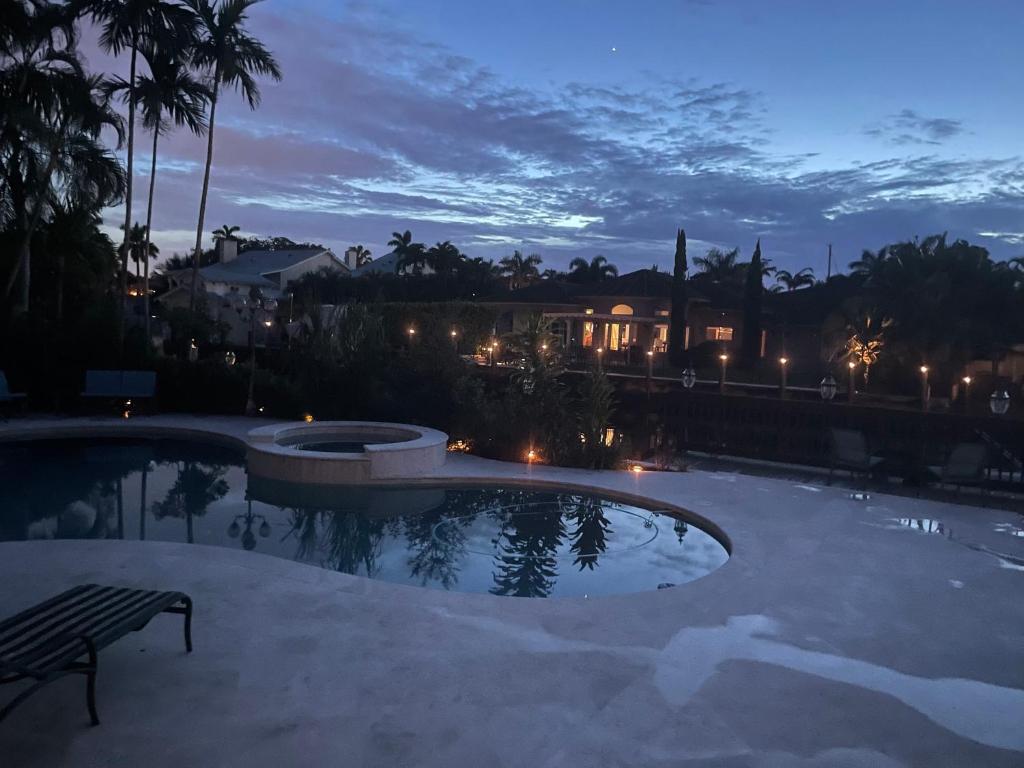 a swimming pool at night with a bench and buildings at Villa Riviera Las Olas in Fort Lauderdale