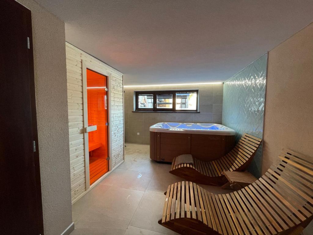 a bathroom with a tub and two chairs in it at Wellness Villa Totina in Liptovský Mikuláš – Demänová