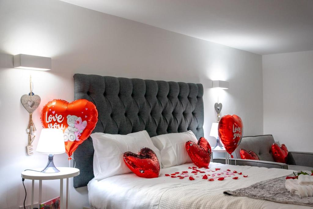 a bedroom with a bed with red heart balloons at Dealhouse Apartments 1 in Huddersfield