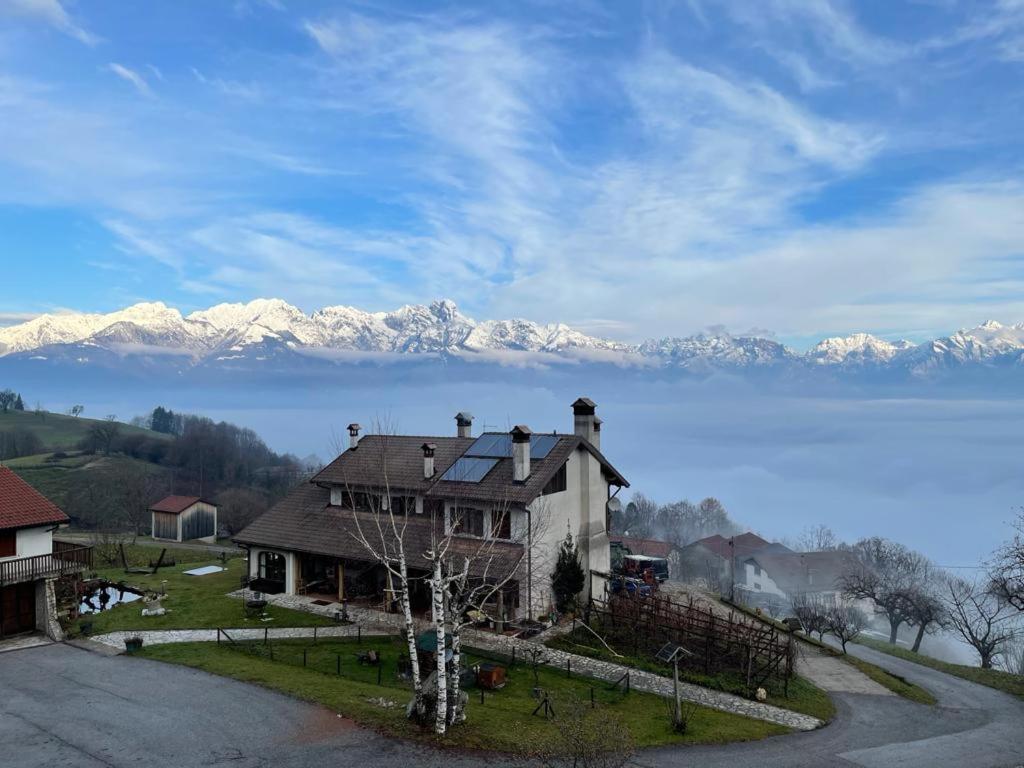 a house with snow covered mountains in the background at Agriturismo Bon Tajer in Colderù