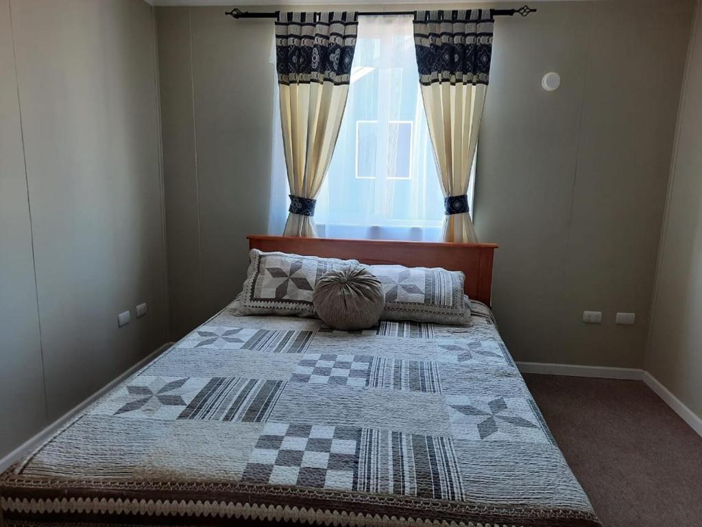 a bedroom with a large bed with a window at Casa Bilbao Villarrica in Villarrica
