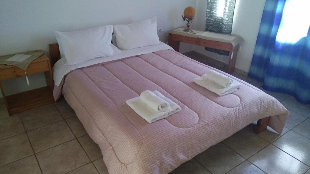 sypialnia z dużym łóżkiem z dwoma ręcznikami w obiekcie Villas Irene 6 Family Apartments w mieście Gournes