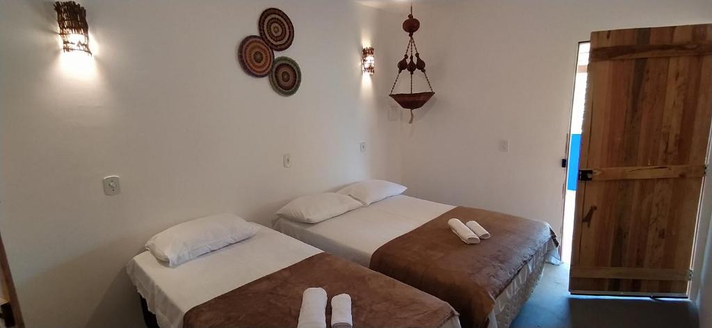 a bedroom with two beds and a door to a room at Al Mare_ BG in Barra Grande