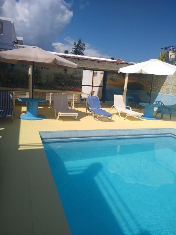 basen z krzesłami i parasolami w obiekcie Villas Irene 6 Family Apartments w mieście Gournes