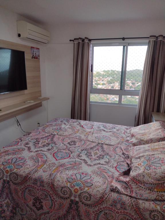 1 dormitorio con cama y ventana grande en VERANO PONTA NEGRA PRAIA - AP 1906, en Natal