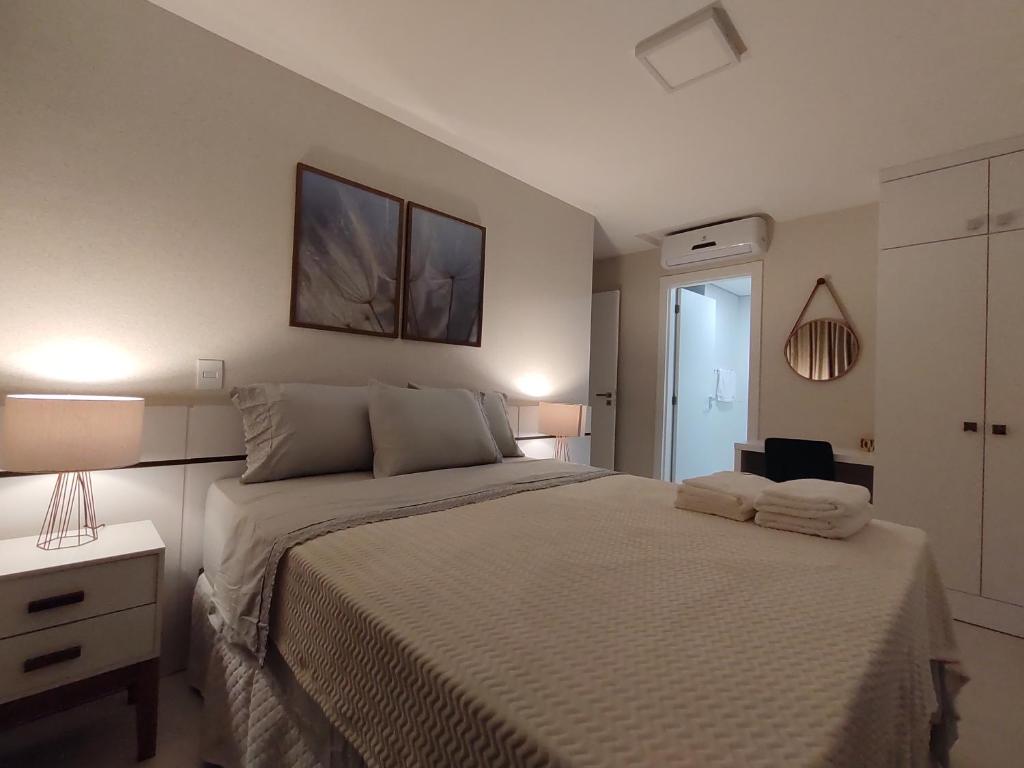 um quarto com uma cama grande com duas toalhas em Apartamento Vida Boa em Gravatal