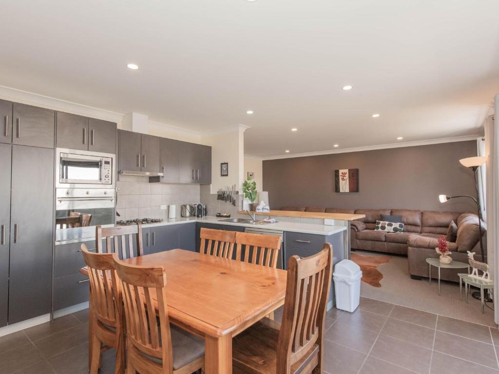 a kitchen and living room with a wooden table and chairs at Jackson Hole 3 in Jindabyne
