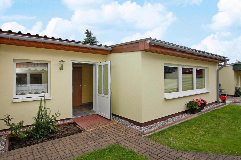 a house with a door and a yard at Cottage, Karl Hagen in Ostseebad Karlshagen