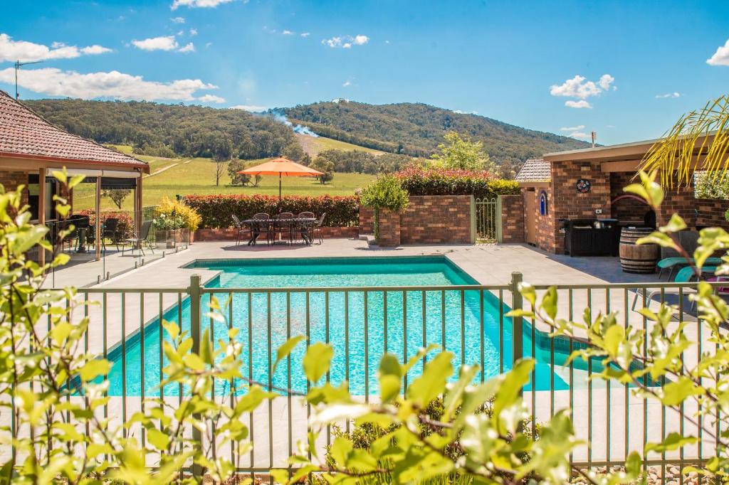 a house with a swimming pool in a yard at Langbrook Cottages in Yarra Junction