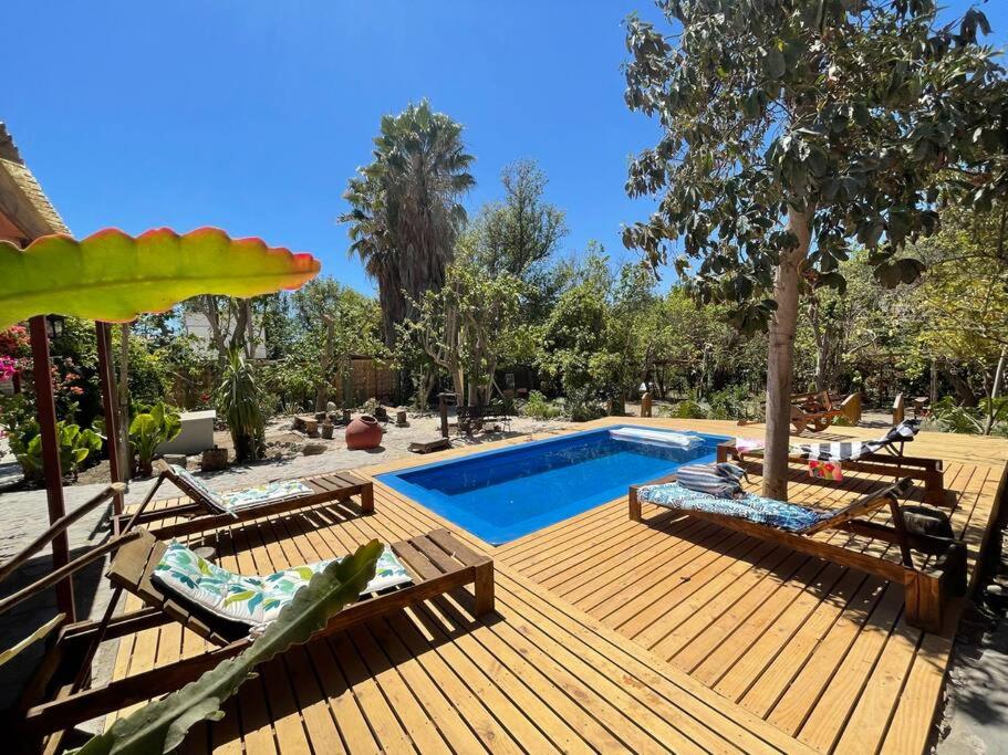 een houten terras met een zwembad en stoelen bij Casa campestre Valle del Elqui in Diaguita