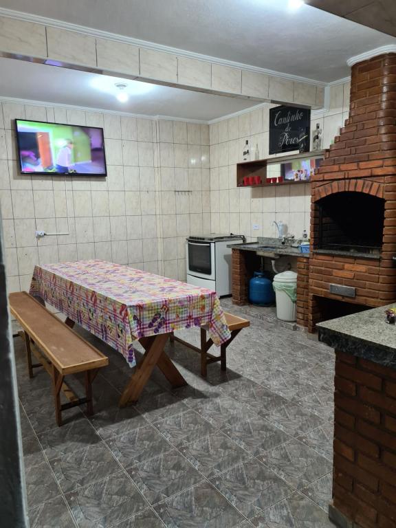 a kitchen with a table and a kitchen with a fireplace at Casa grande e confortável até 16 pessoas com churrasqueira e garagem para 8 carros in Praia Grande