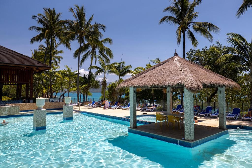 un complejo con piscina con playa y palmeras en Fitzroy Island Resort en Fitzroy Island
