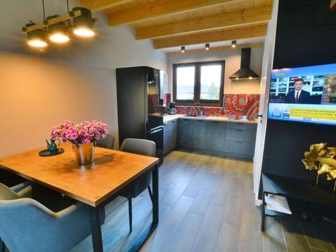 a kitchen with a table and a kitchen with a tv at Holiday house sauna whirlpool Mielenko in Mielenko