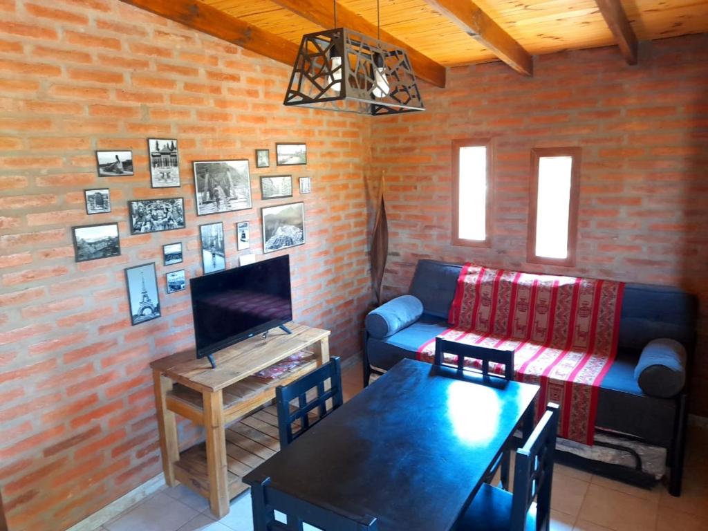 uma sala de estar com um sofá e uma mesa em Cabaña EL ZORZAL de Villa del Dique em Villa del Dique