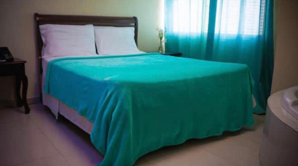 Postel nebo postele na pokoji v ubytování Hotel Luis V Santo Domingo