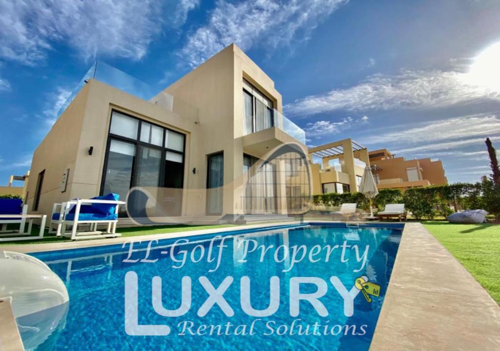 a villa with a swimming pool in front of a house at Tawila Villa T1-15 in Hurghada