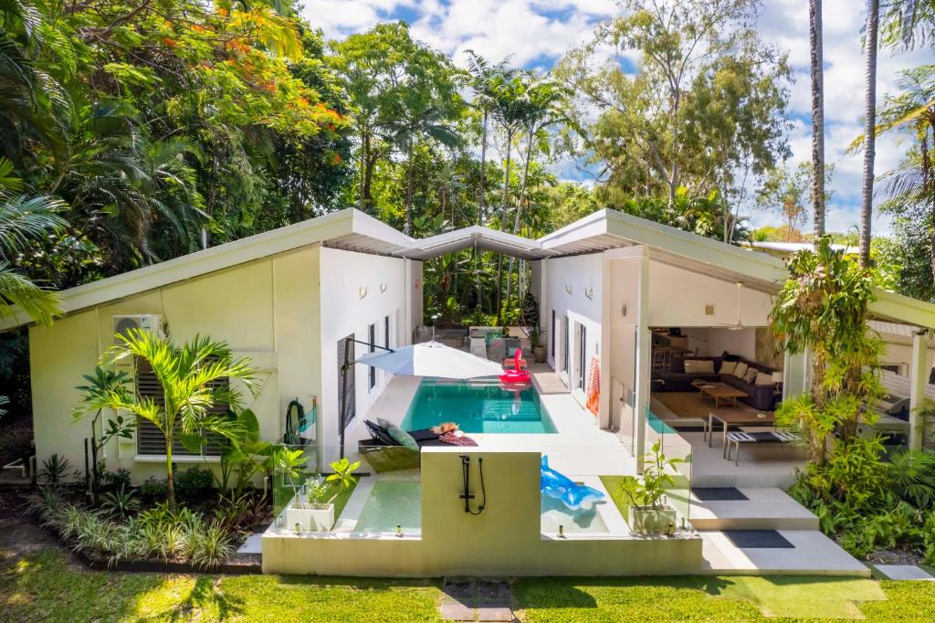 una vista exterior de una casa con piscina en Pavilions in the Palms Heated Pool Short Path To Beach Five Bedrooms Sleeps 14, en Port Douglas