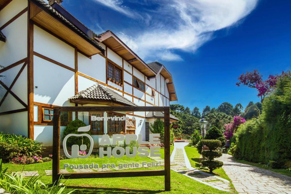 a house with a sign in front of it at Pousada Apple House - Campos do Jordao in Campos do Jordão