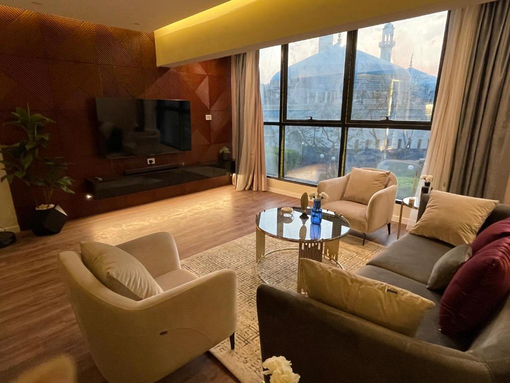 Family Luxury apartment at Milsa Nasr City , Building 27 في القاهرة: غرفة معيشة مع كنب وتلفزيون وطاولة