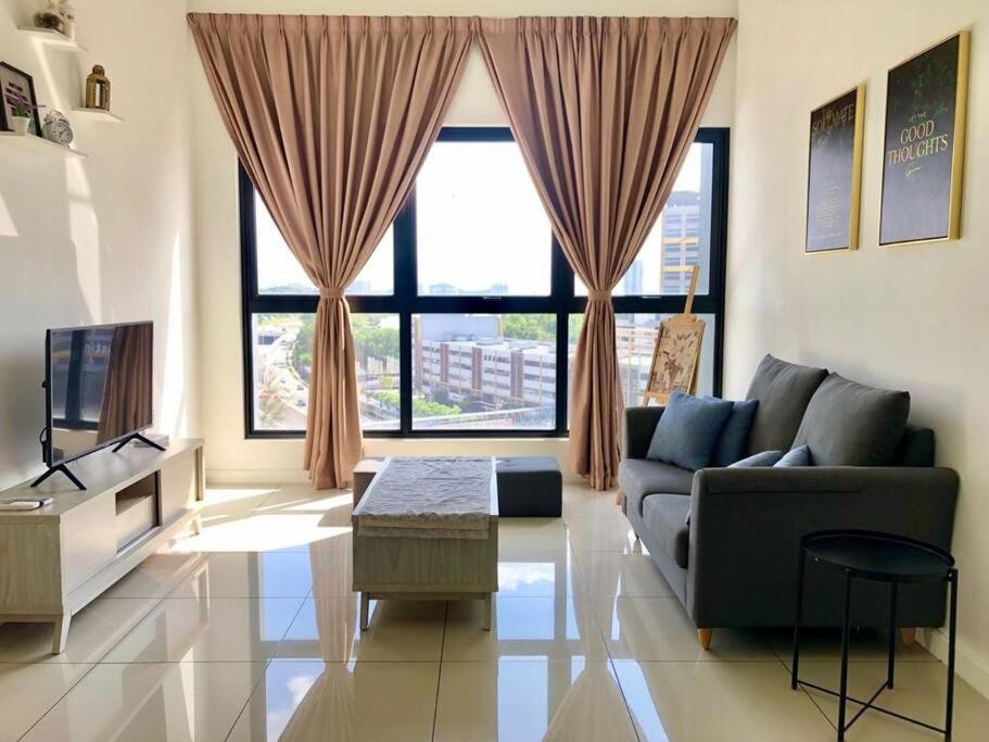 a living room with a couch and a large window at Cozy Mayfair Homestay in Puchong